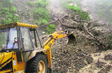 A JCB machine clears debris at Hara Bagh on the Mandi-Pathankot NH-20.