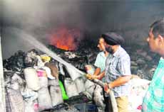 Firemen douse flames at a rubber factory in Jalandhar on Tuesday.