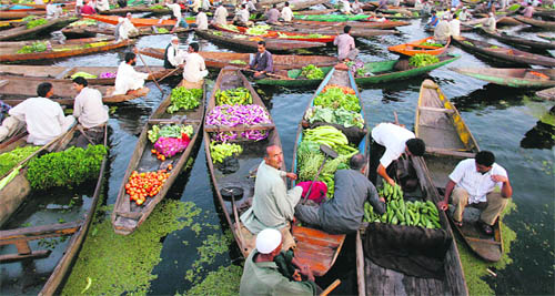 Boatmen bring their boats post dawn to the Dal Lake's floating vegetable market to sell their produce in Srinagar on Tuesday.