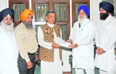 SGPC chief Avtar Singh Makkar hands over a memorandum to External Affairs Minister SM Krishna in Delhi on Tuesday