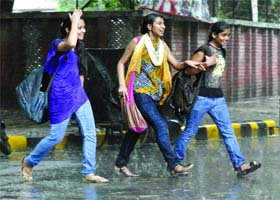 THREE IS COMPANY: Girls have fun in the rain in New Delhi on Wednesday