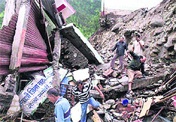 People look for survivors in the debris of buildings that collapsed after a cloudburst in Uttarkashi