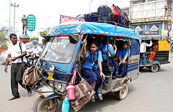 An autorickshaw carrying school kids more than the permissible number, on a city road