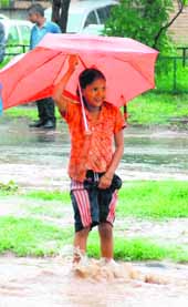 A girl crosses a flooded road during rain at Sector 5, Panchkula, on Friday.