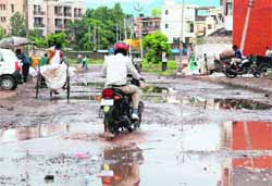 A girl crosses a flooded road during rain at Sector 5, Panchkula, on Friday.