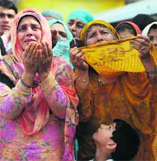 A child looks on while Kashmiri Muslim women pray at the Hazratbal shrine during the third Friday of Ramadan in Srinagar. 