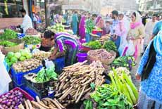 People buy vegetables at a market in Srinagar.