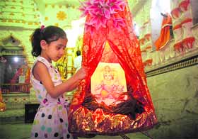 A girl pulls Lord Krishnas jhula on the occasion of Janmashtami in Jammu on Friday. 