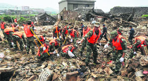 Paramilitary men search for victims in the debris of destroyed houses after a flood caused by a dam breach.