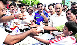 Vyapar Sena activists distribute sugar free of cost among the public in front of the Local Bodies Minister Bhagat Chunni Lals residence at JP Nagar in Jalandhar on Saturday