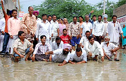 Congress workers squatted in stagnant water on a street in Lal Singh Basti to protest against the indifference of the municipal corporation towards civic woes