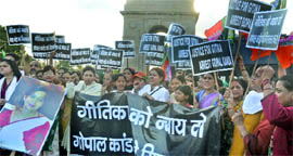 BJP activists hold a candlelight march, demanding the arrest of former Haryana Minister Gopal Kanda in the Geetika Sharma suicide case, at India Gate in New Delhi on Sunday.