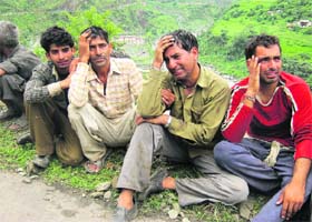 Relatives of some of the deceased grieve at a village in Chamba