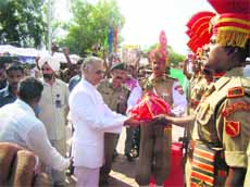 Punjab Governor Shivraj Patil presents sweets to BSF jawans at Hussainiwala checkpost on Monday.