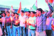 Supporters of Ramdev hold a candlelight welcome rally in Haridwar on Monday