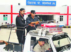 Armed policemen posted near the entrance to the railway station in Rohtak on Monday. 