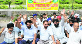 Former employees of the SRTC stage a protest in support of their demands in Jammu on Monday.