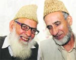 Newly elected president of Jamaat-e-Islami Mohammad Abdullah Wani (R) shakes hands with former president Sheikh Mohammad Hassan at Batamaloo in Srinagar. Photo: Amin War