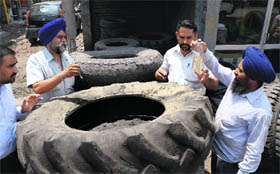 Officials of the district Health Department test a sample of stagnant water taken from an old tyre at Transport Nagar in Ludhiana on Monday.