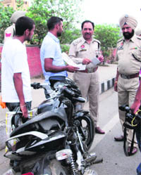 Police officials check documents of motorcyclists on the eve of Independence Day in Amritsar on Tuesday.