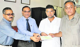A delegation of Usha Breco company gives a cheque for Rs 5 lakh to Chief Minister Vijay Bahuguna for Uttarkashi victims in Dehradun on Tuesday.