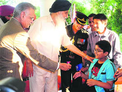 UT Administrator Shivraj V Patil and Punjab Chief Minister Parkash Singh Badal felicitate a differently abled boy, Aryan Jain, who had come to greet Patil during the At Home function at Punjab Raj Bhawan in Chandigarh.