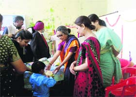 Members of the Mussoorie Rotary Club give away prizes to students at Bhatta village on Wednesday