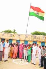 Birmati, mother of only a girl child, unfurls the Triclour at Bibipur village of Jind district on Wednesday. 