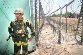 A BSF jawan stands guard at the international border in Samba district