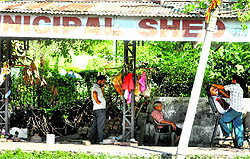 A rain shelter being used by a barber to run his business in Jammu
