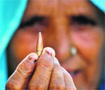 A woman shows a bullet which had hit her house in Abdulian.