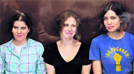 Members of the female punk band 'Pussy Riot' sit in a glass-walled cage during a hearing in Moscow.