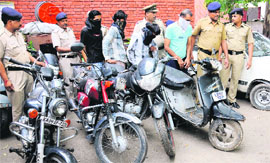 The accused, along with stolen two-wheelers, in police custody.