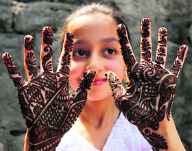 A girl shows the design of henna applied to her hands in Srinagar.