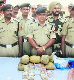 Border Security Force officials with the seized contraband and fake currency in Ferozepur sector. 