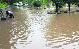 Workers try to clear the blocked drainage at the Rock Garden parking area in Chandigarh on Sunday.