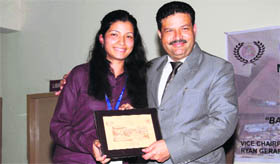 Chairman of Law College, Dehradun, Jitendra Joshi presents a memento to a participant of the Model United Nations Conference in Dehradun on Sunday.