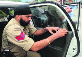 A policeman removes black film from a car in Reasi on Sunday