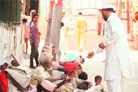 Beggars seek alms on the eve of Eid outside a mosque at Talab Khatikaan in Jammu on Sunday