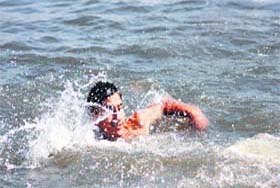 A boy swims in the Dal lake to beat the heat in Srinagar on Sunday