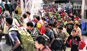 North-East migrants, who fled from different parts of the country after rumours of attacks, arrive at the Guwahati railway station on Sunday.