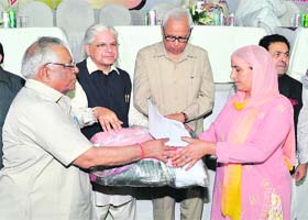 Jammu and Kashmir Governor NN Vohra (centre) gives away relief to a terrorist victim at a function organised by the Punjab Kesari Group of Newspapers in Jalandhar on Sunday