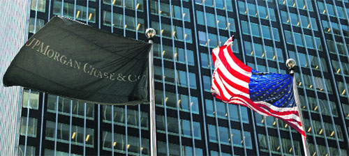 A JPMorgan flag (L) and a US flag wave outside the JPMorgan headquarters in New York City. Asian banks are reviewing relationships with their US counterparts to avoid being caught by tough new American rules on derivatives trading that are about to come into force. From the start of next year, non-US banks that annually deal in at least $8 billion worth of products such as interest rate swaps with American counterparties are expected to be subject to new derivatives rules in the Dodd-Frank Act.