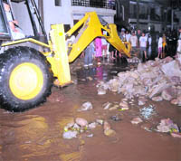 A JCB breaks the road in Phase IV to provide an outlet for rain water in Mohali on Monday. 