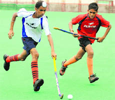 Players in action during a match at the Sector-42 hockey stadium in Chandigarh on Monday. 