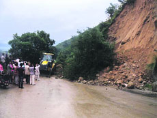 A landslide blocks the Pathankot-Mandi national highway near the Kangra airport on Monday.