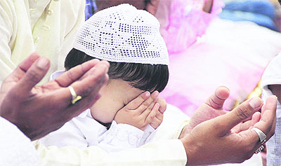 A toddler offers prayers with folded hands during Eid-ul-Fitr celebrations in Jalandhar on Monday.