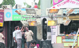 Employees of the Power Development Department repair flood lights at the Jammu railway station on Monday.