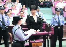 A court police officer hands over the verdict to Gu Kailai during her trial at Hefei Intermediate Peoples Court in this still image taken from video on Monday