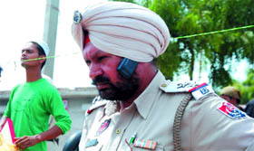 A cop improvises to attend to frequent calls he receives while on duty, in Bathinda.